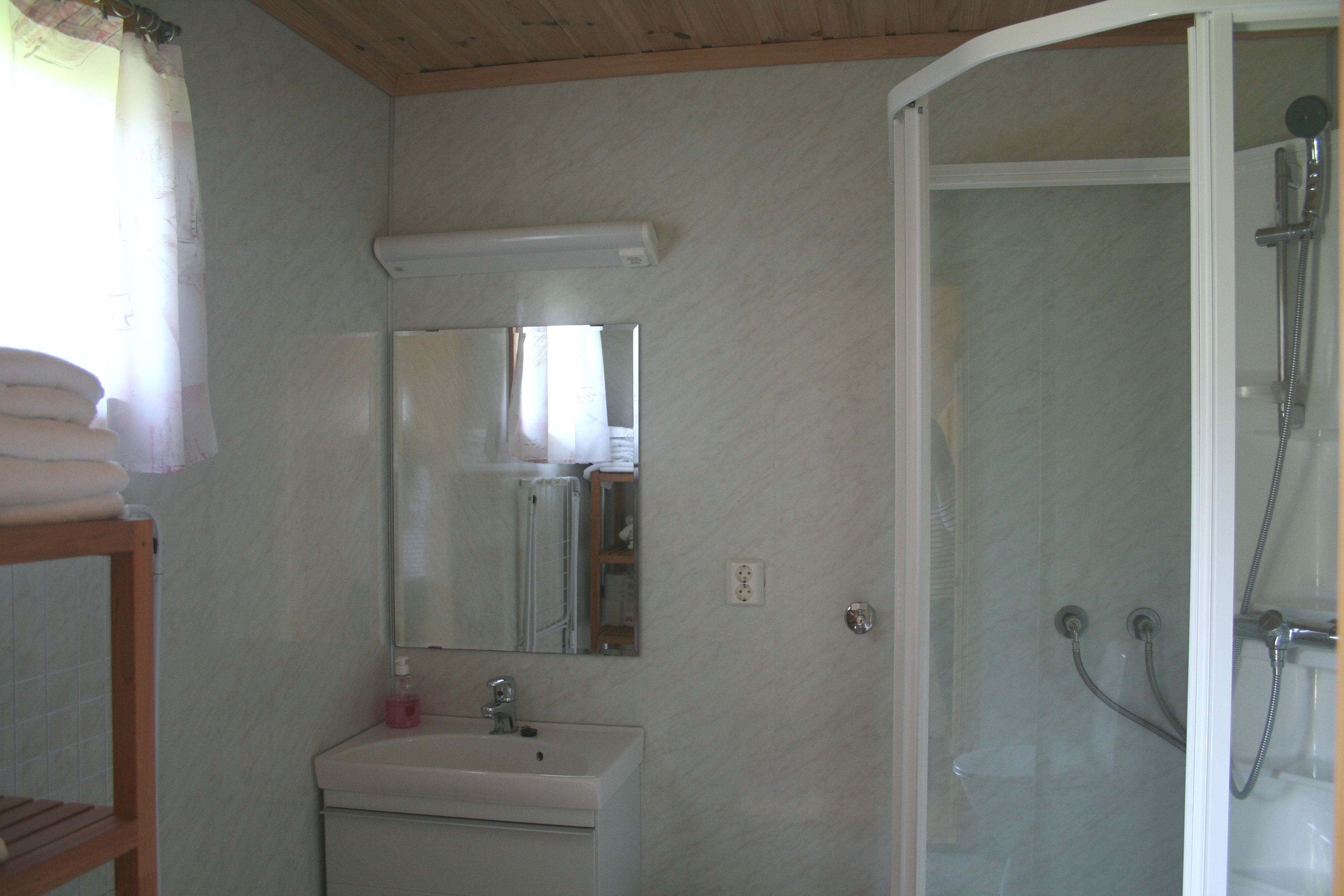 Reint og moderne bad med dusj og servant i hytte på Oddland Camping.