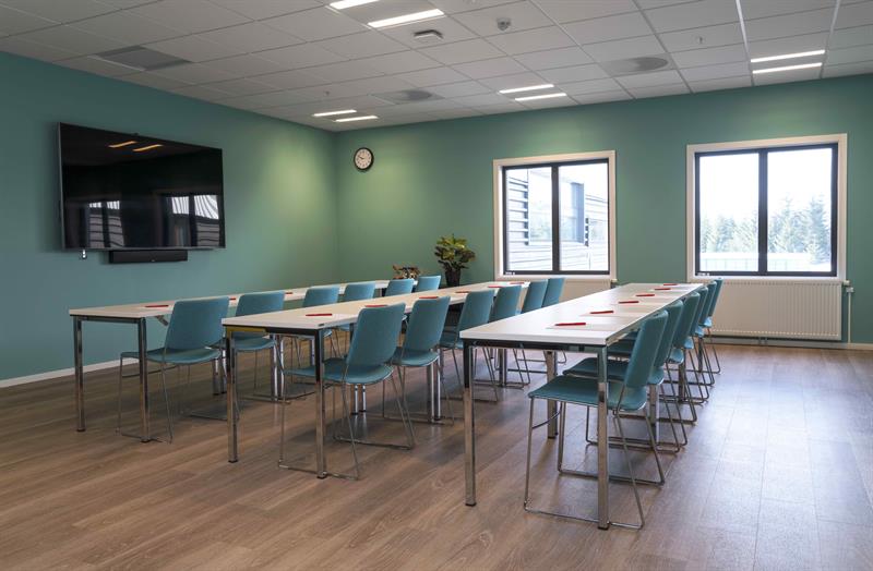 konferanse rom i skoleoppsett med grønne vegger og stoler