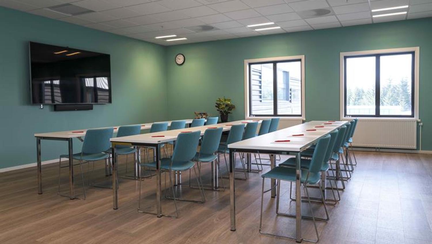konferanse rom i skoleoppsett med grønne vegger og stoler