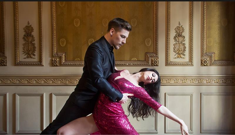 mann i dress og kvinne i rosa kjole danser tango