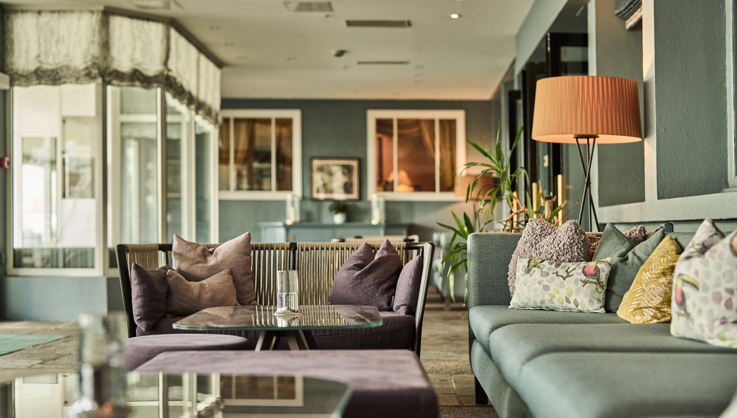 Hyggeleg loungeområde med sofaer og puter på Hotel Ullensvang.