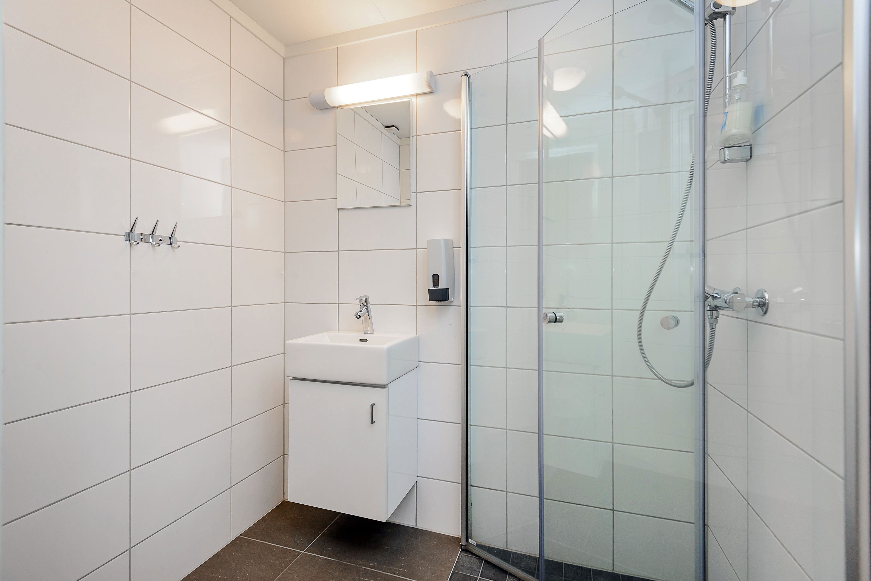 A bathroom with sink and shower.