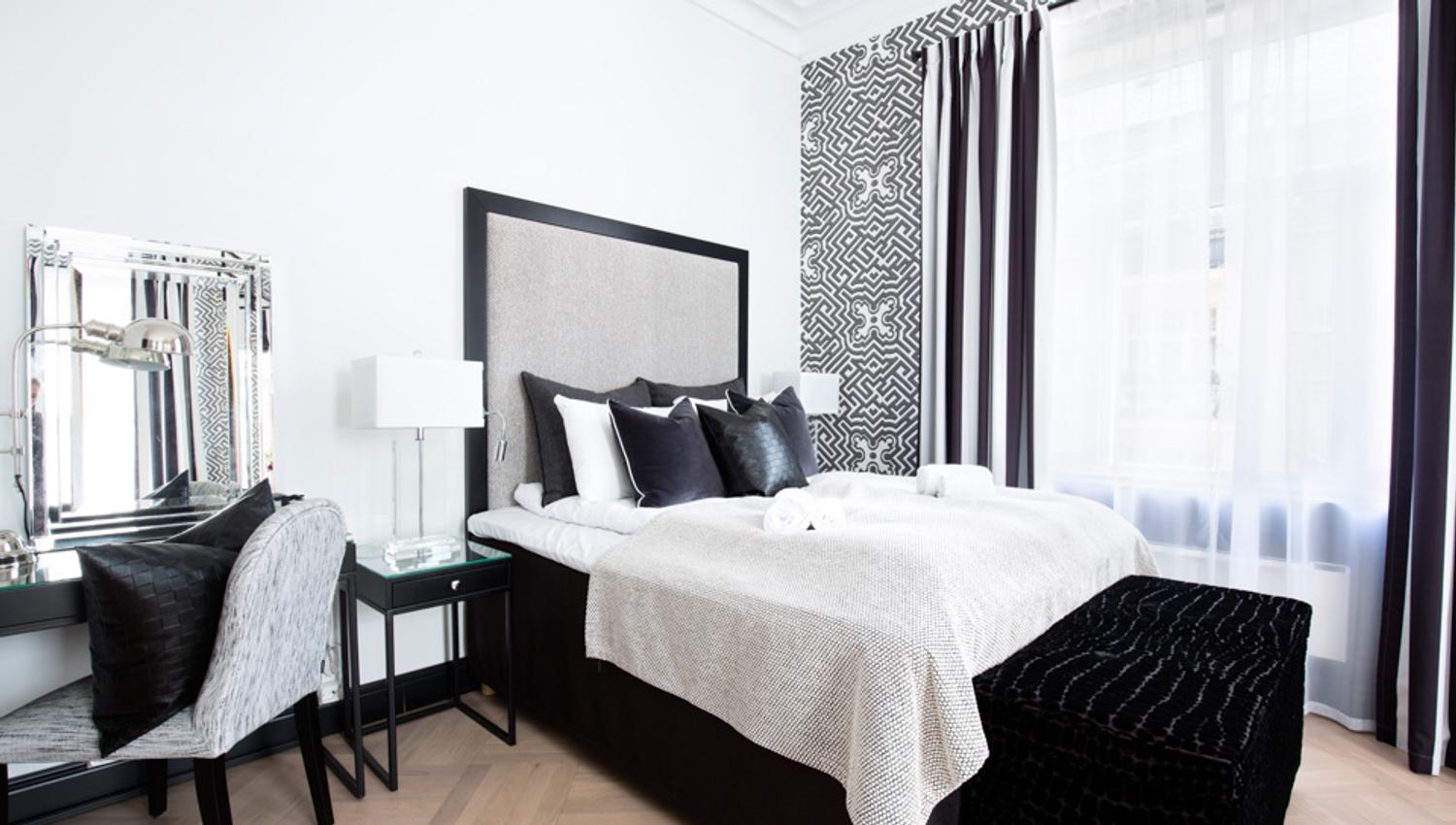 Soverom i sort, grått og hvit på Frogner House Apartments. Seng, skrivebord. foto