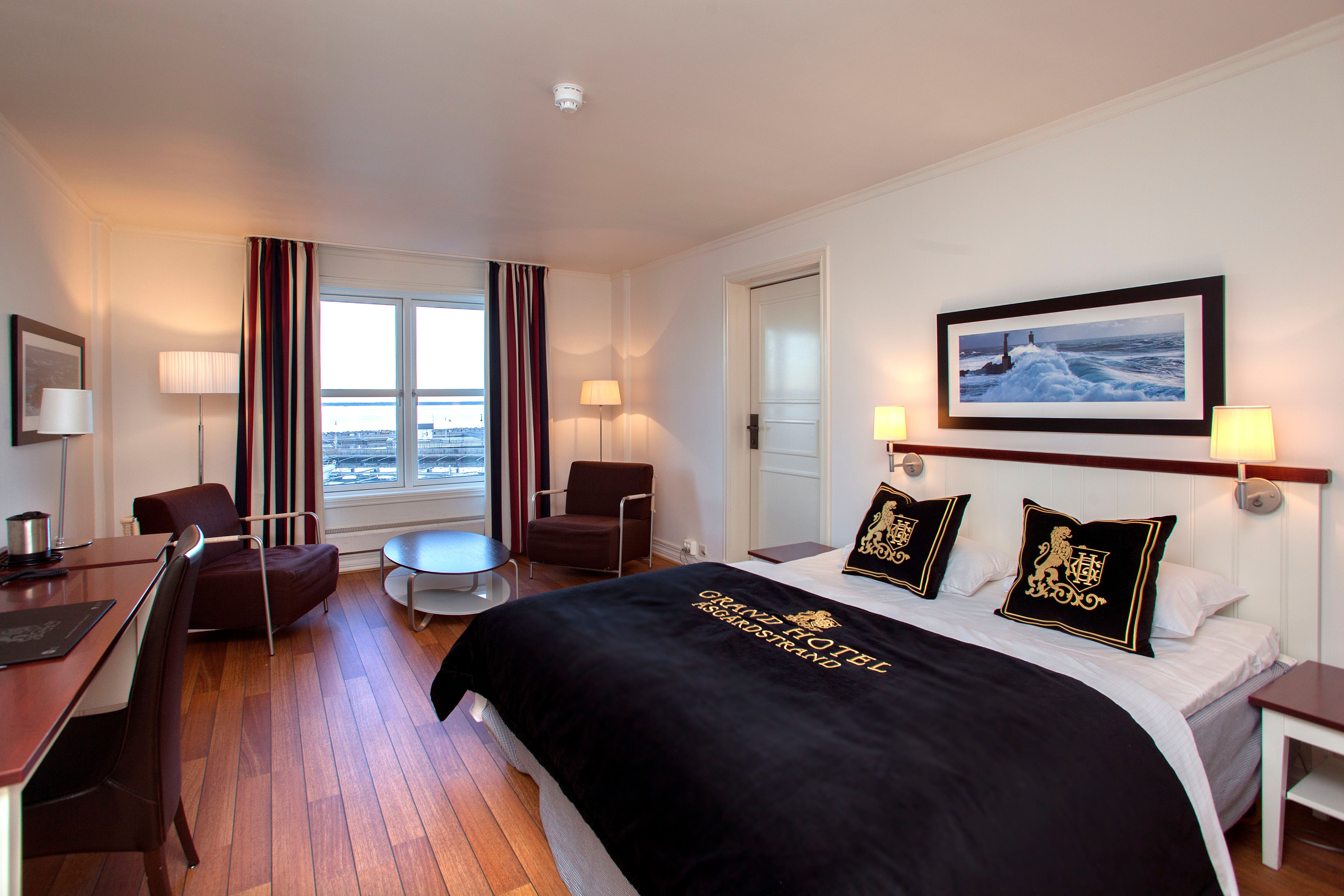 Stor seng og sittegruppe på hotellrommet