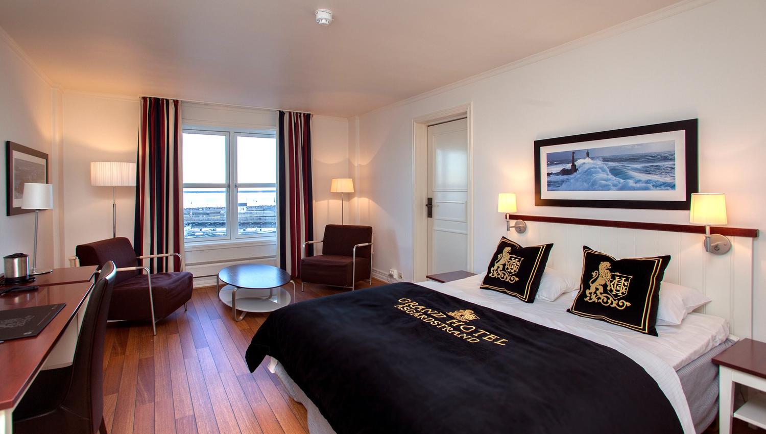 Stor seng og sittegruppe på hotellrommet