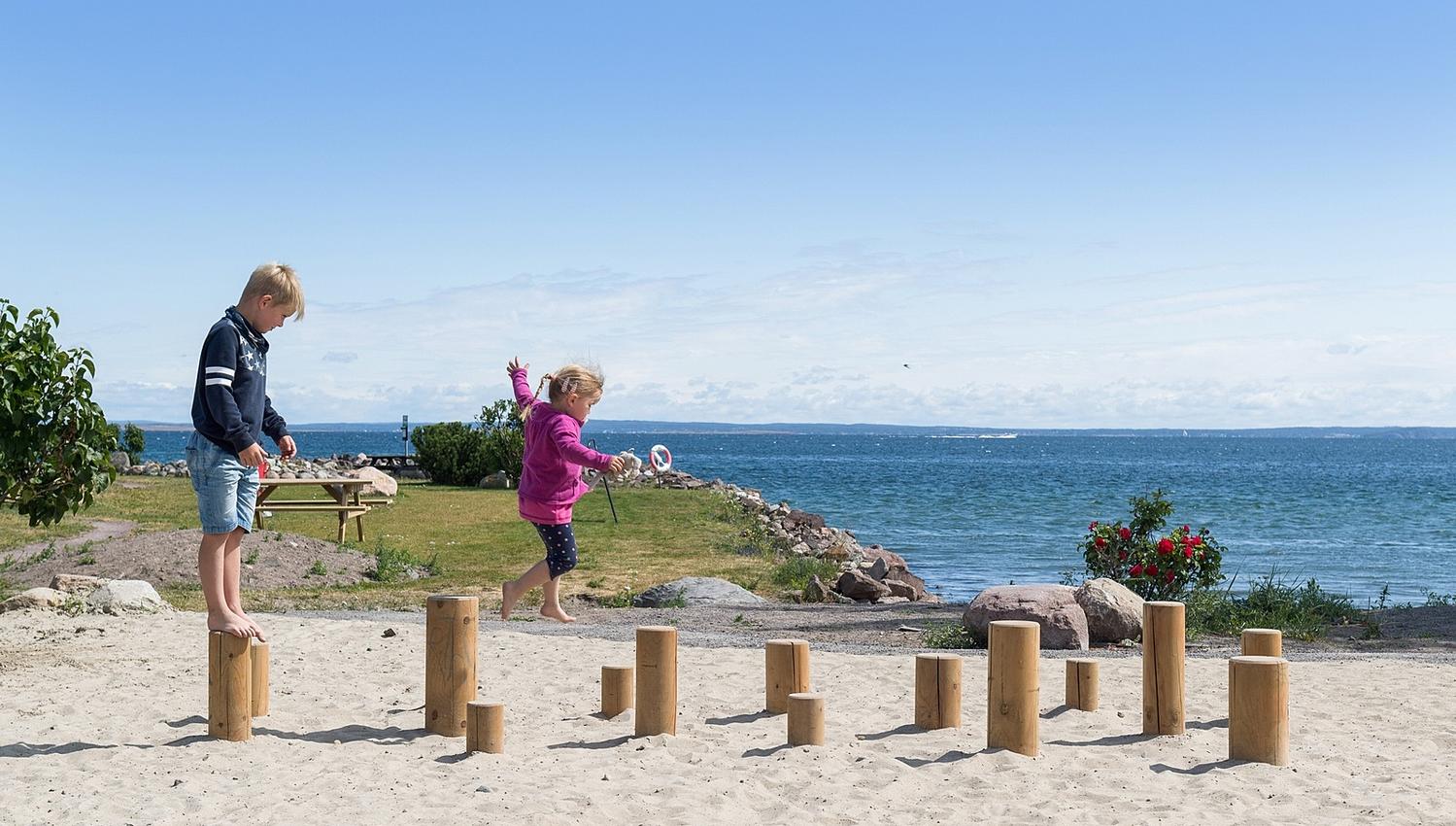 Barn som leker på stranda