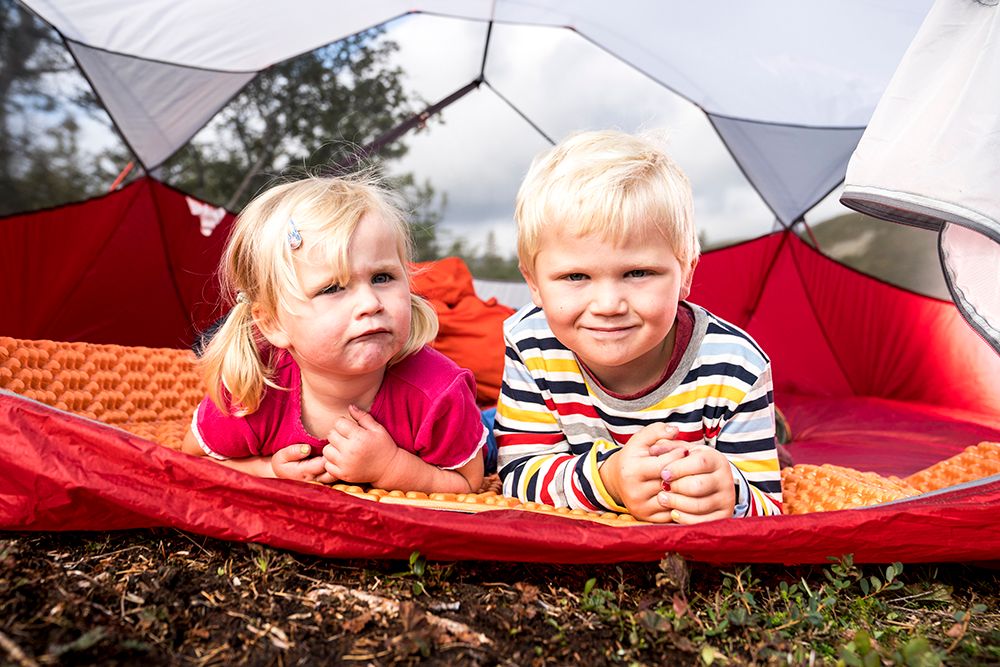 liten gutt og jente ligger i telt på vandretur til tretoppern i Bø