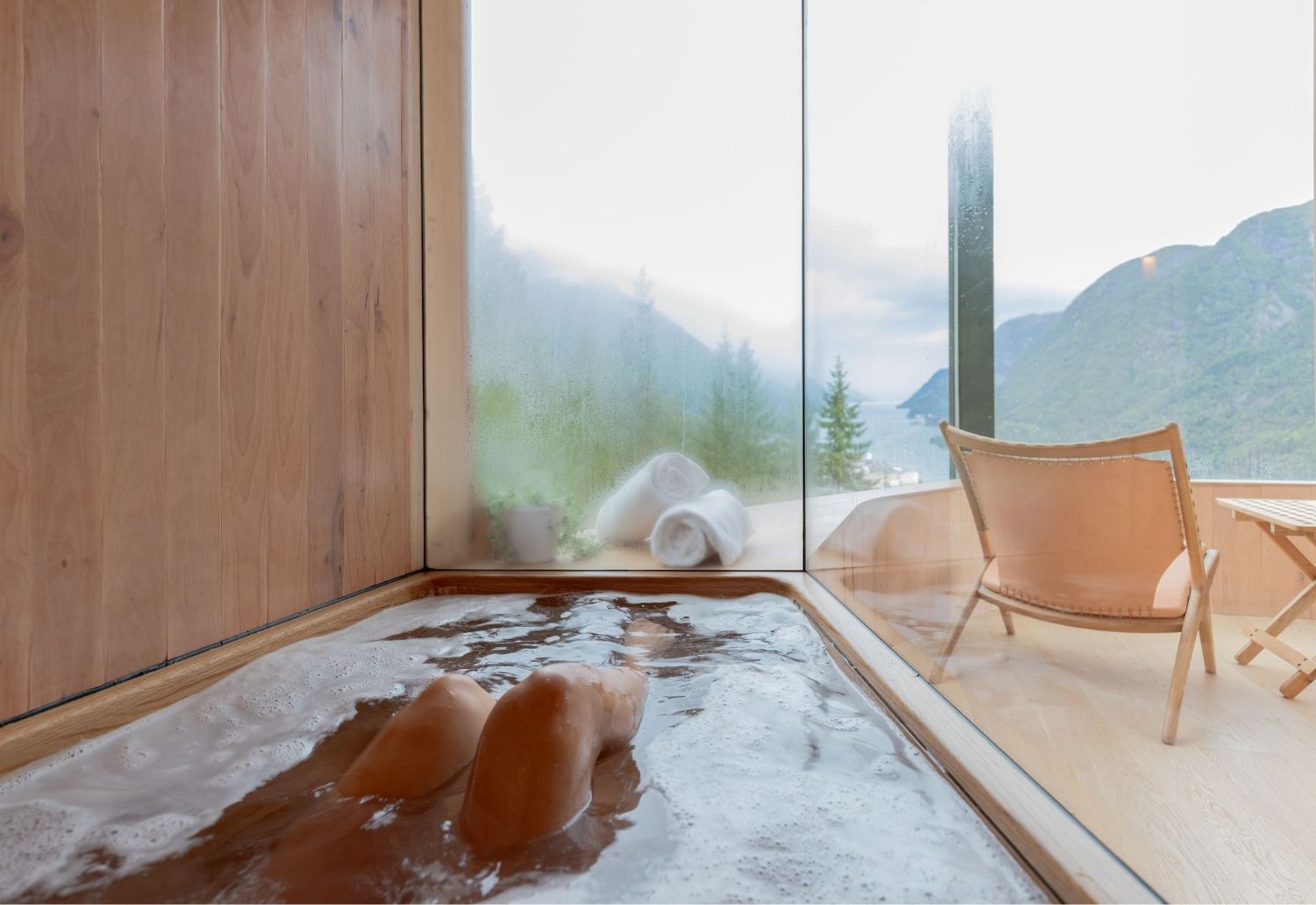 Avslappande bad med utsikt over fjorden og fjella i Woodnest tretopphytte.