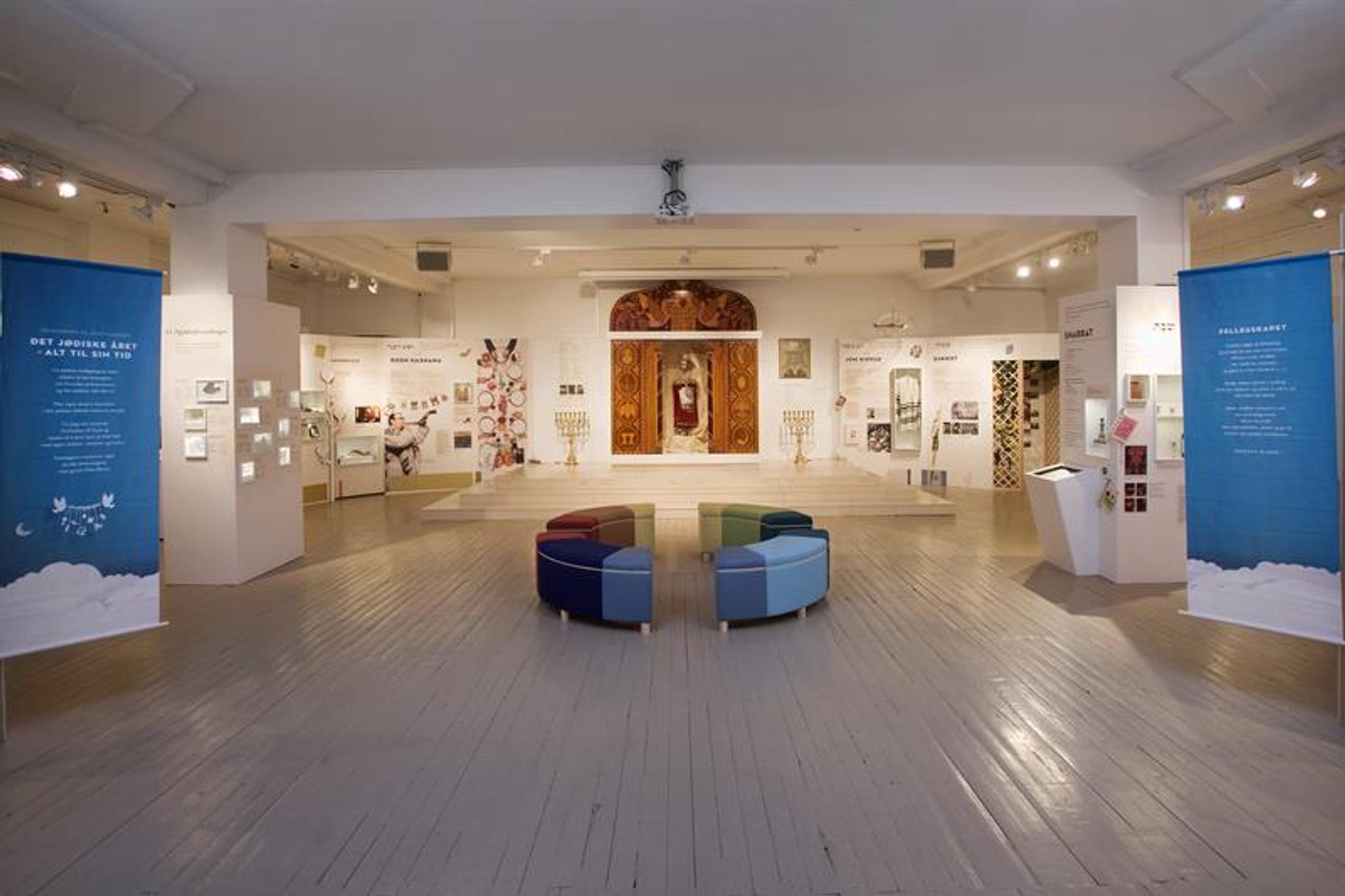 Interiør. Plakater langs veggene, sitteseksjon i midten av rommet.