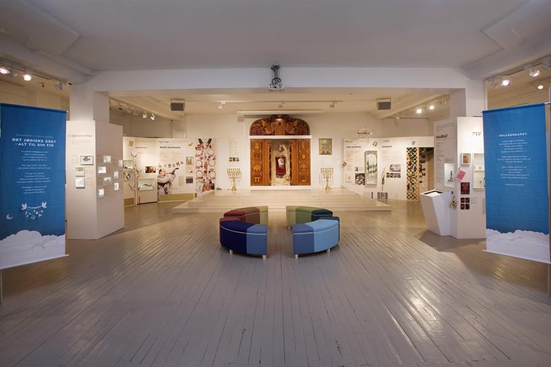 Interiør. Plakater langs veggene, sitteseksjon i midten av rommet.