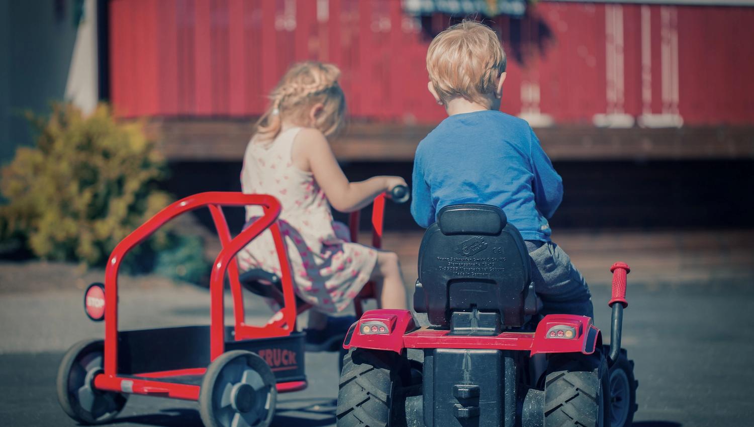 Two children play with toy vehicles