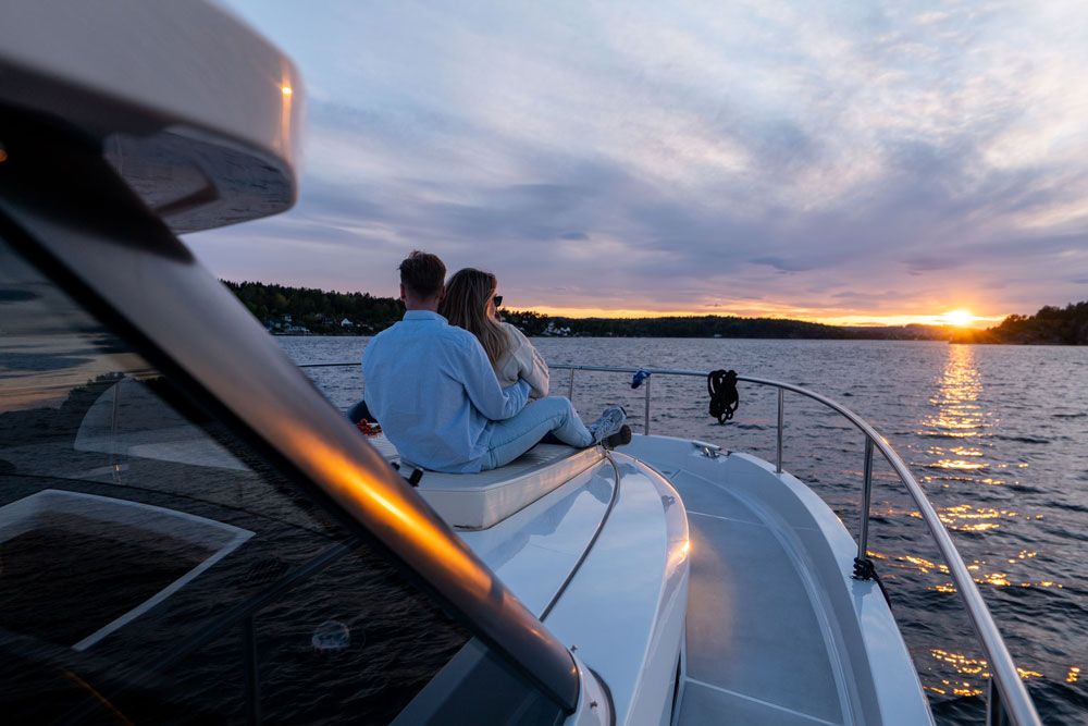 par sitter på dekk og nyter solnedgangen
