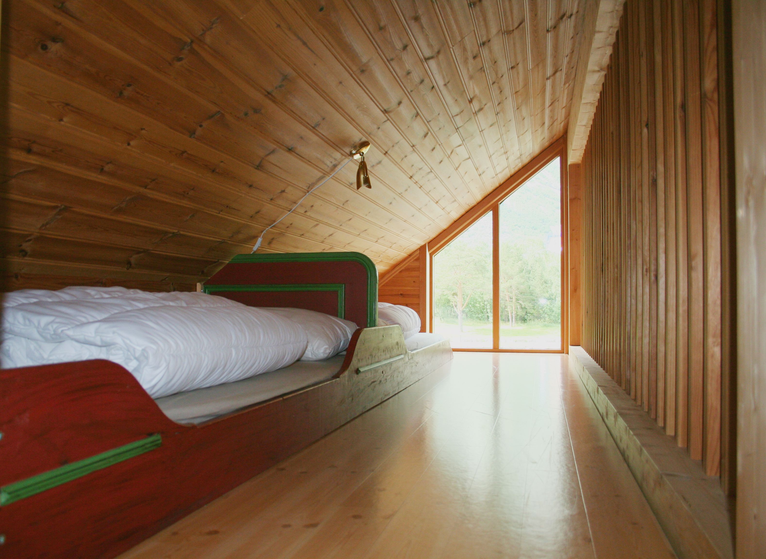 Two red single beds in a bedroom in the attick.