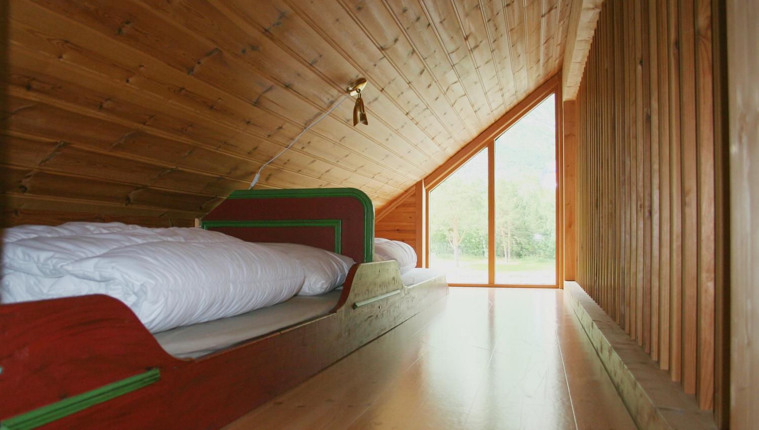 Two red single beds in a bedroom in the attick.