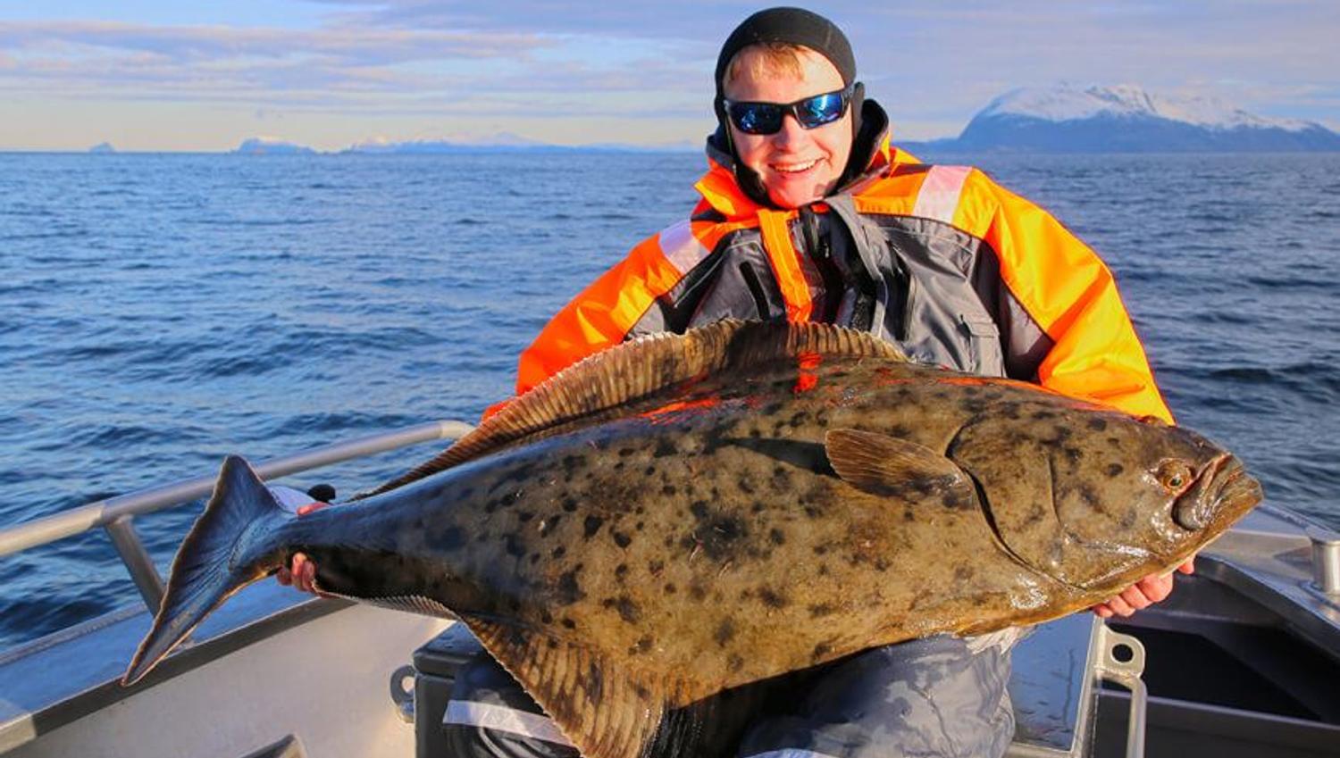 Man holding a halibut on a fishing trip with Explore the Arctic
