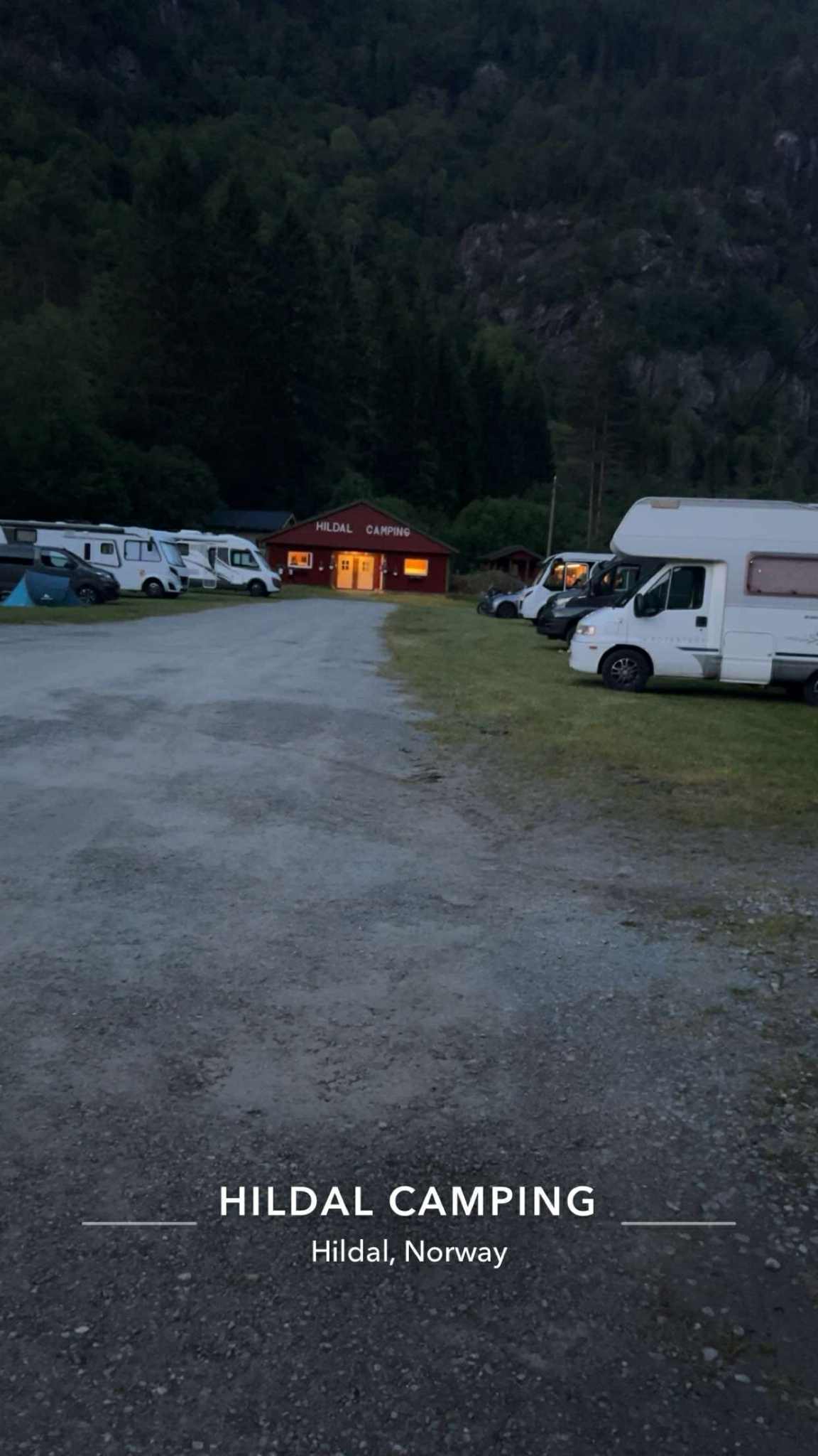Kveldsstemning på Hildal Camping med lys frå servicebygget og bubilar parkert.
