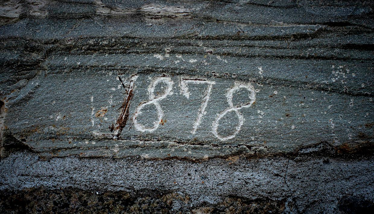 Stein med inngravert årstalet "1878" på Helleland Gard, som viser garden sin lange historie.