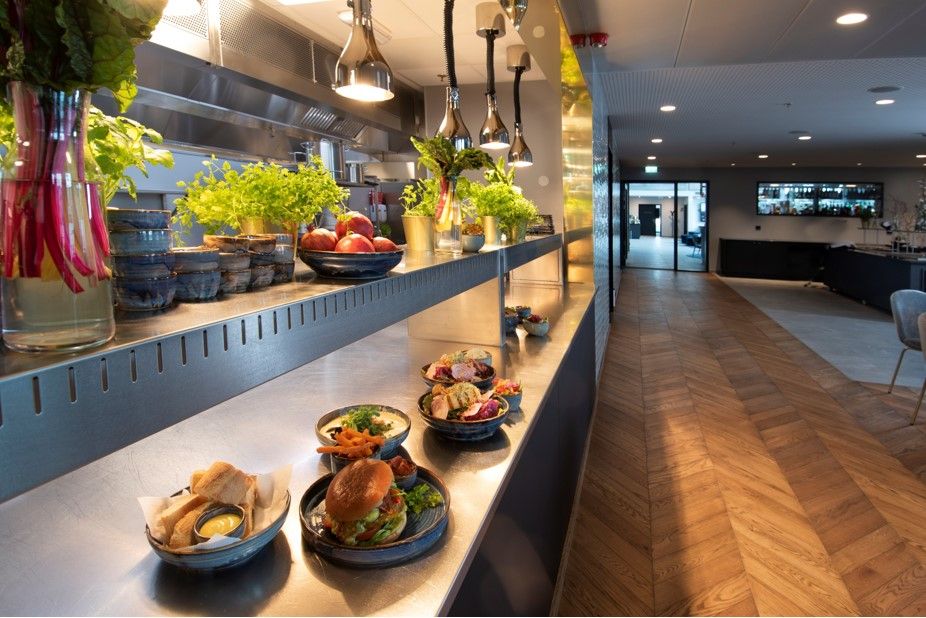 Mat fra Mandal Hotel, 4 forskjellige skåler. En med oppskåret bagett med noe  gult å dyppe i. En med svær burger med masse grønt i + pommes frites. To med ulike salater. 
Det er også fire små skåler med frukt