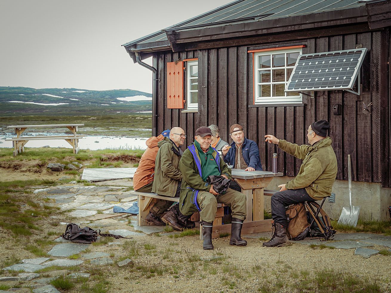 A group of men are sitting around a table, talking and smiling.
