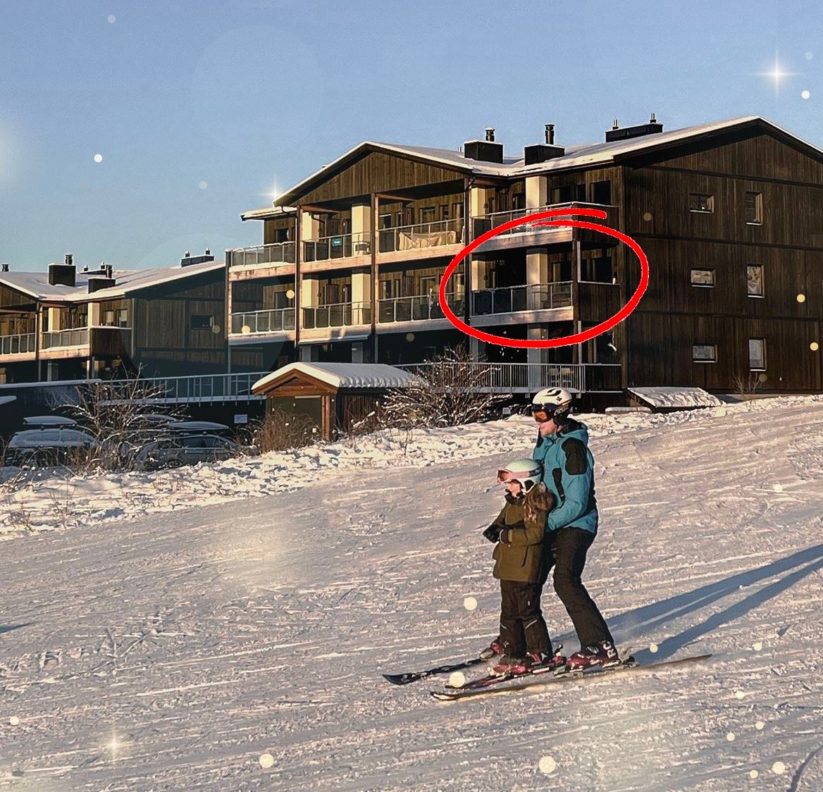 A person and a child skiing in the snow.