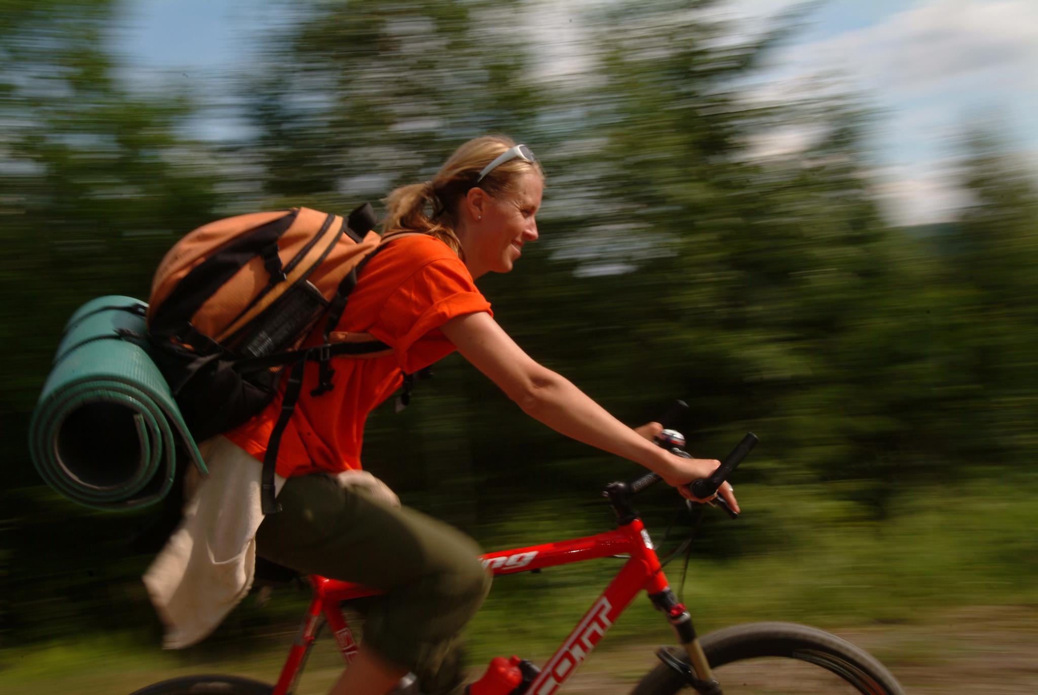 a woman with a backpack on a bicycle