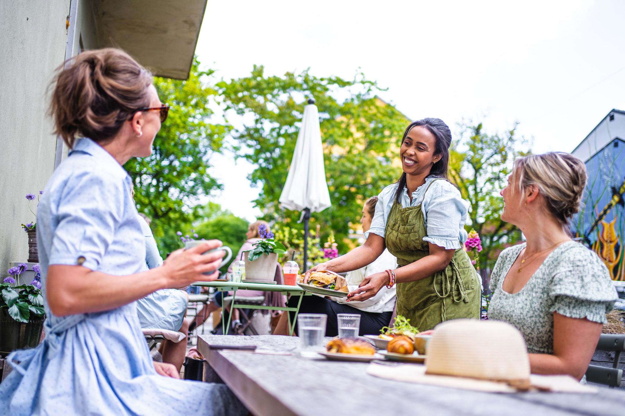 gjester på en kafe som får maten sin