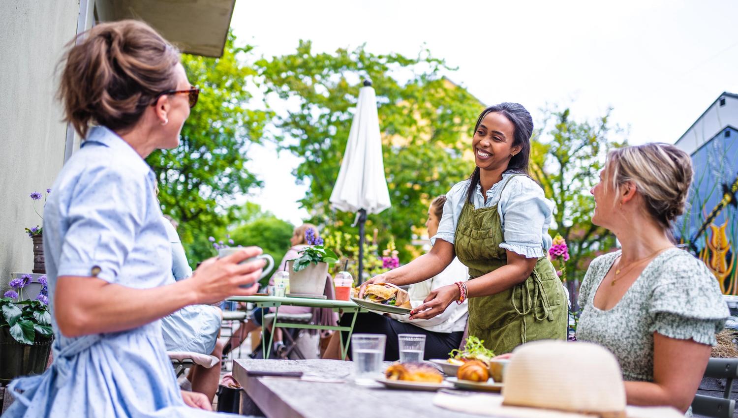 gjester på en kafe som får maten sin