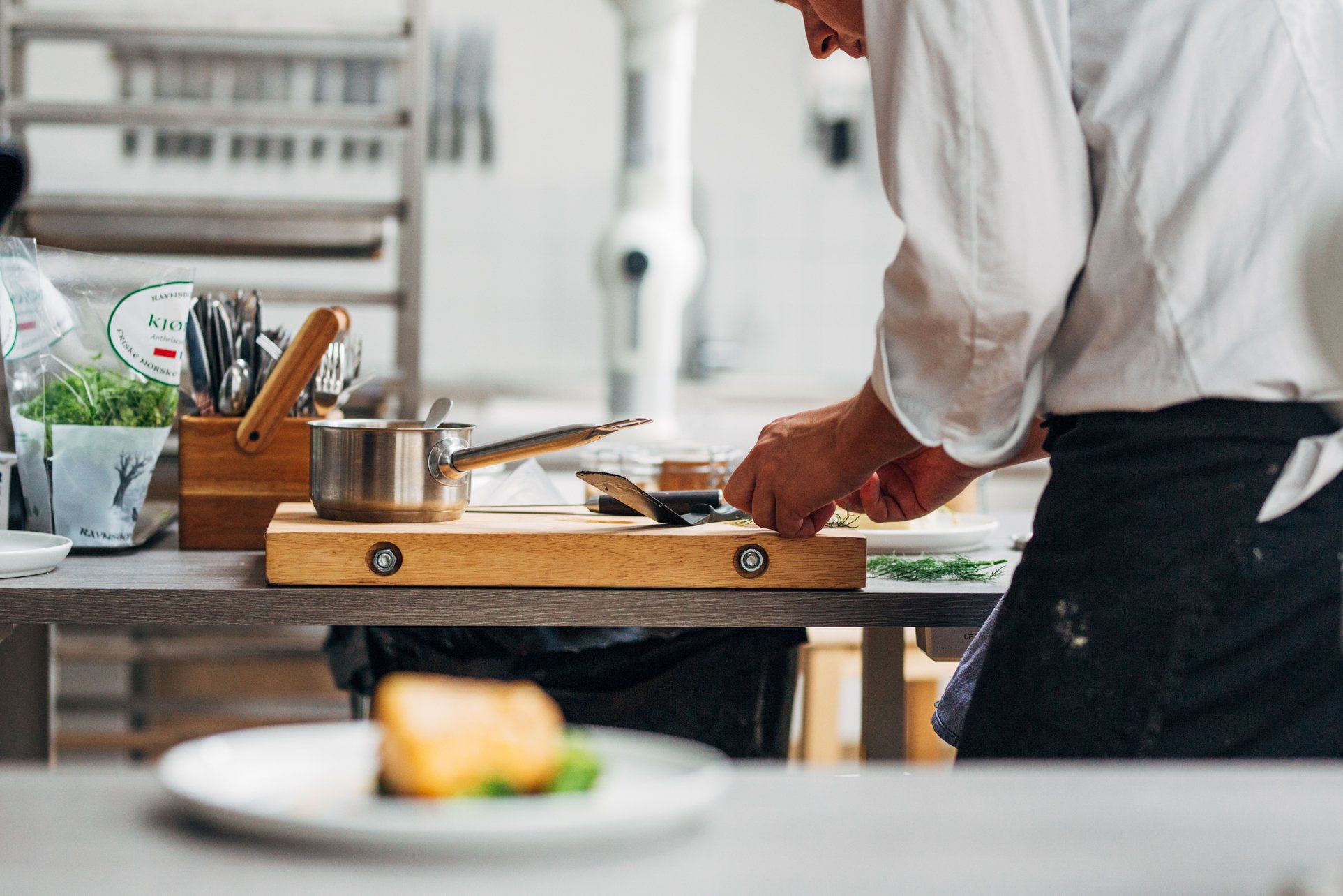 Kjøkkensjef kutter mat på en fjøl
