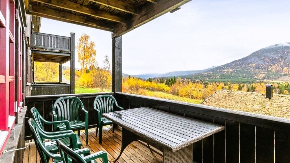A group of green plastic chairs on a terrace.