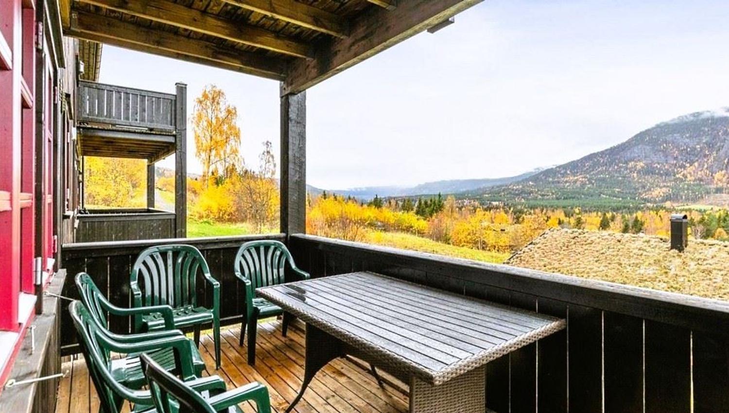 A group of green plastic chairs on a terrace.
