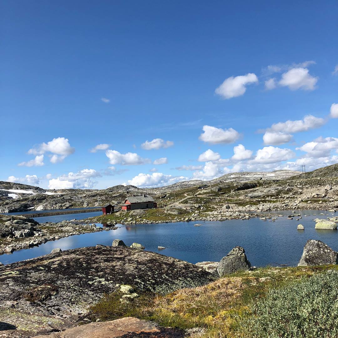 Raud hytte ved fjellvatn på Rallarvegen mellom Hardanger og Hallingskarvet ein solrik sommardag.