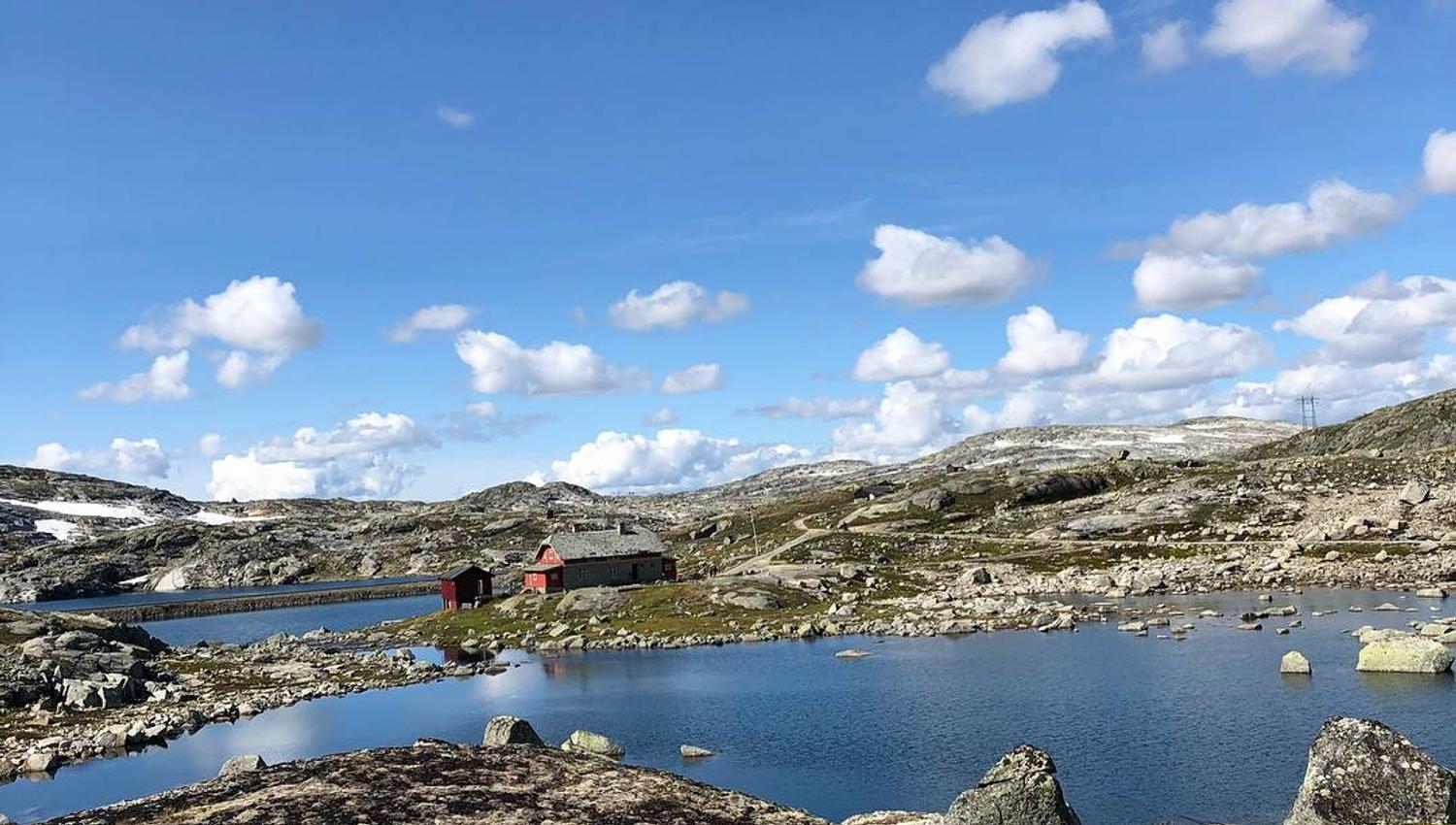Raud hytte ved fjellvatn på Rallarvegen mellom Hardanger og Hallingskarvet ein solrik sommardag.