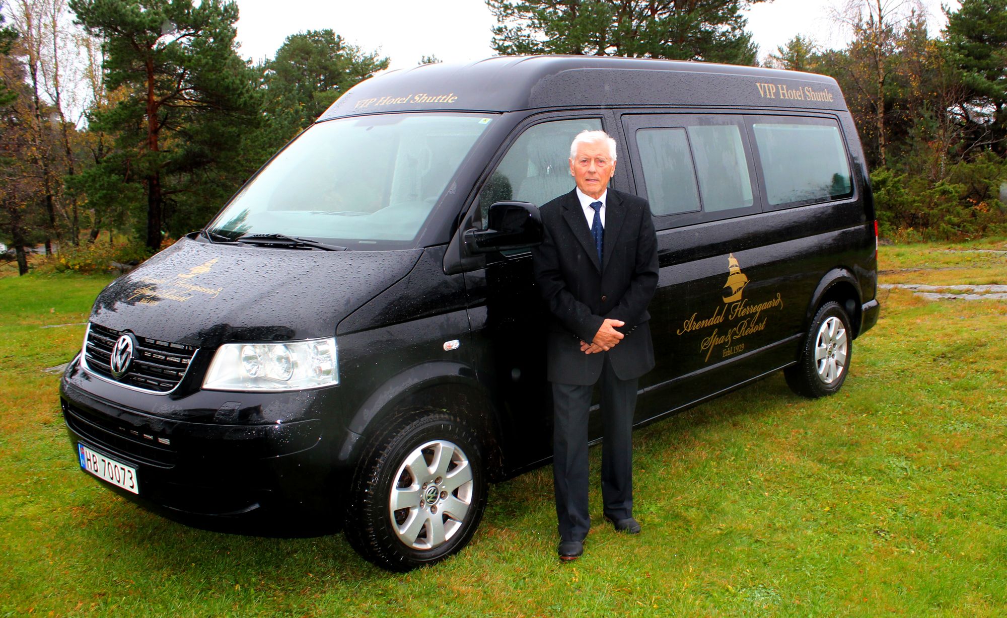 Arendal Herregaard Spa & Resort's VIP Shuttle med sjåfør foran bilen.