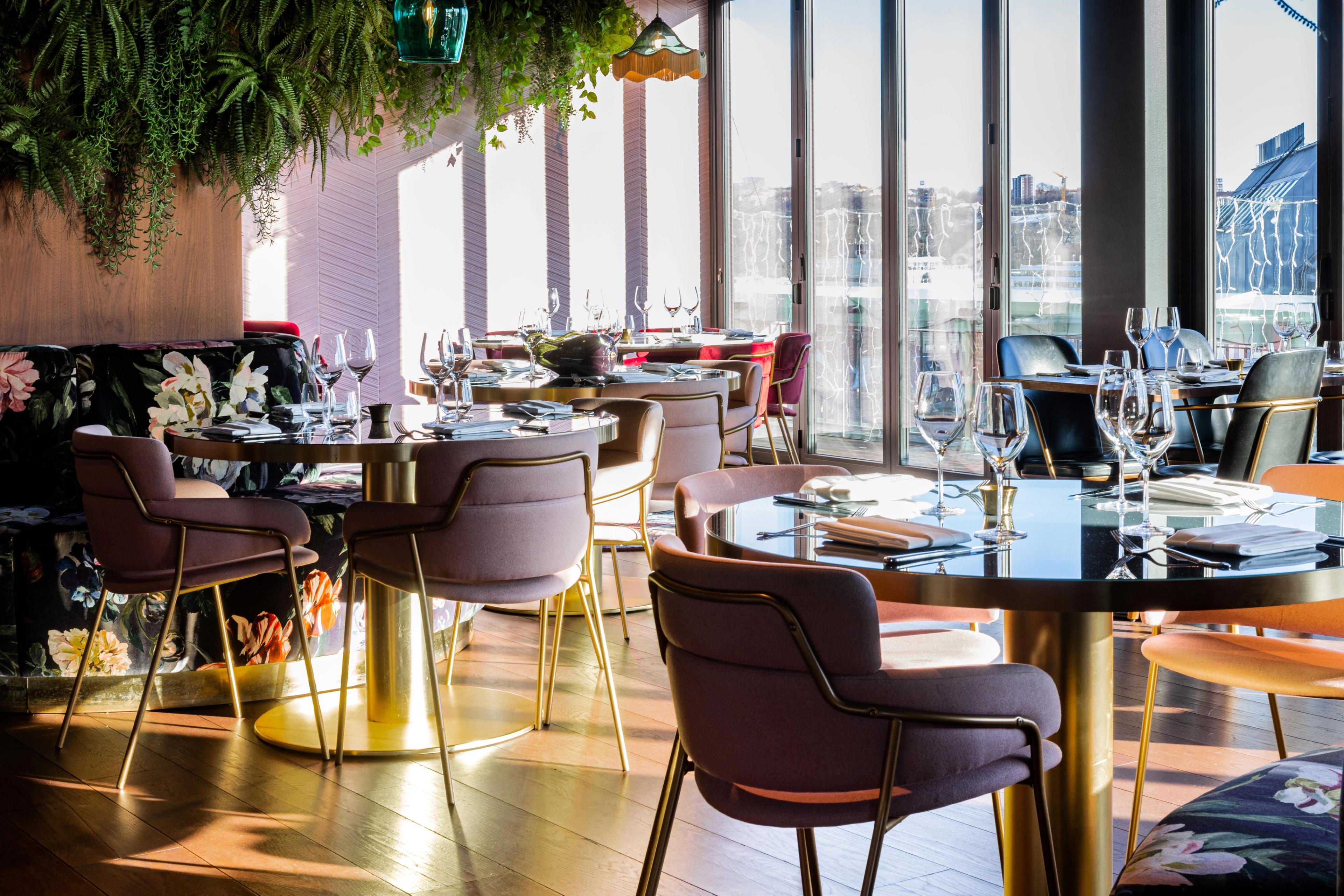 Round small tables with chairs in front of large panoramic windows