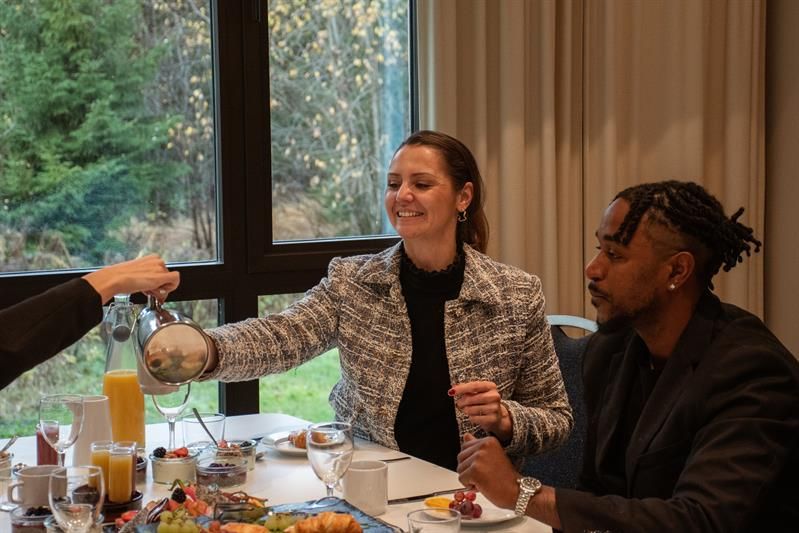 to personer sitter ved et dekket bord og nyter et måltid i en hyggelig restaurant