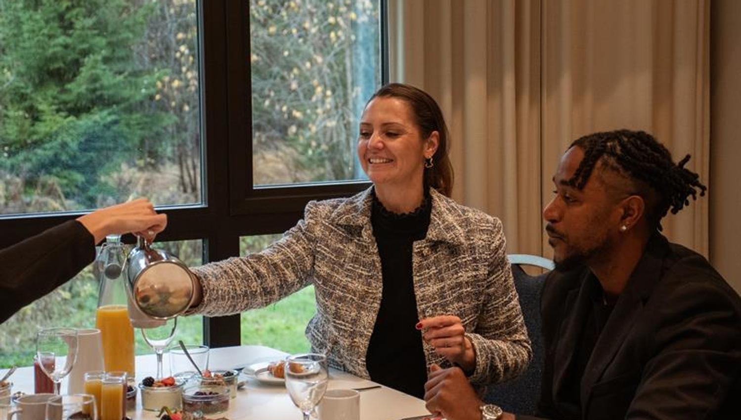 to personer sitter ved et dekket bord og nyter et måltid i en hyggelig restaurant