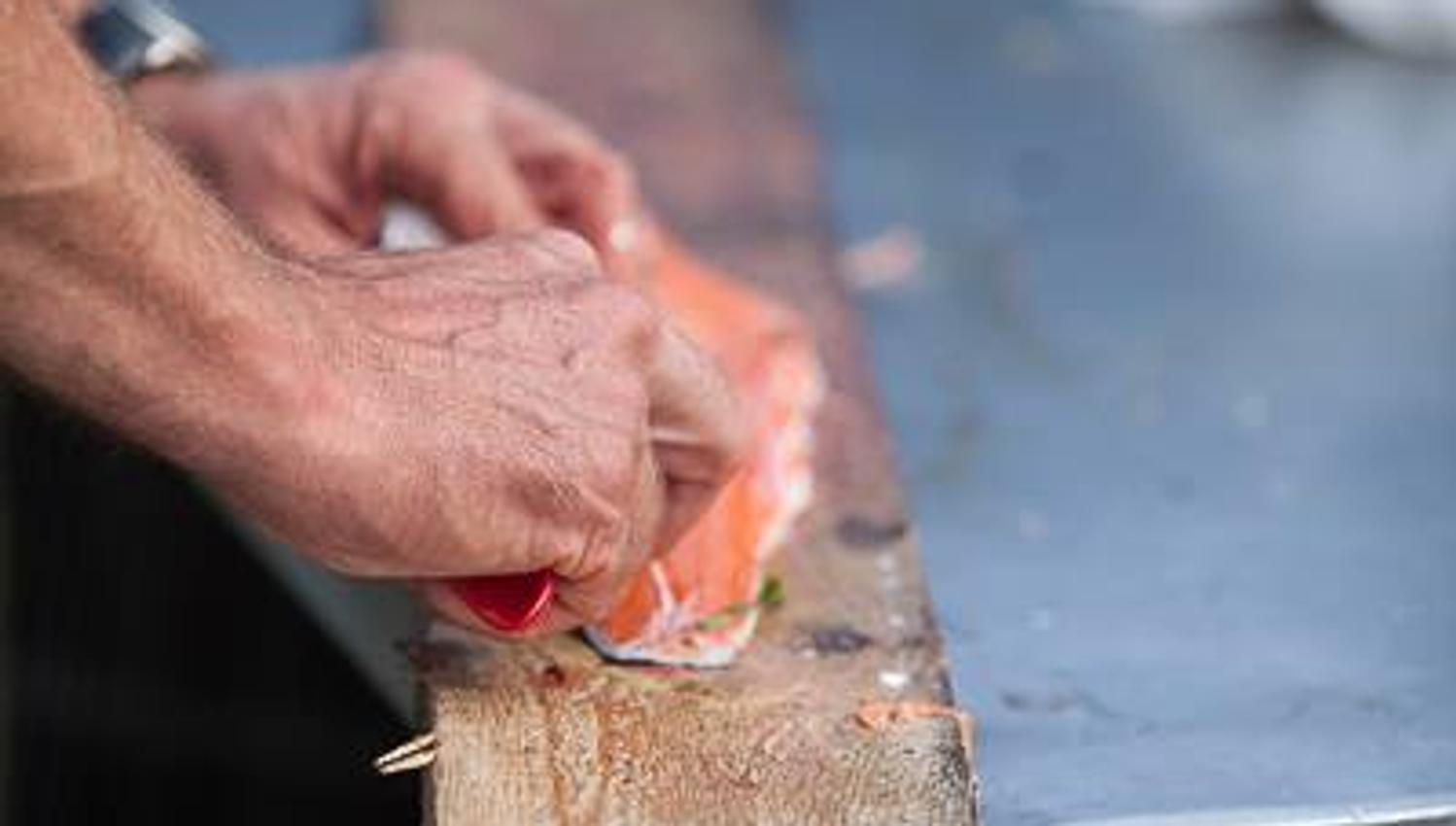 En som fileterer ett fiskestykke