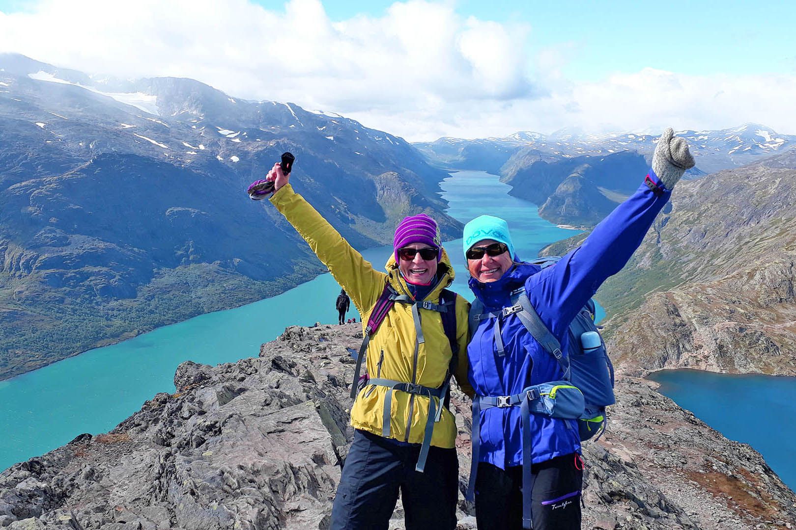 To glade vandrere på en fjellegg med stor utsikt