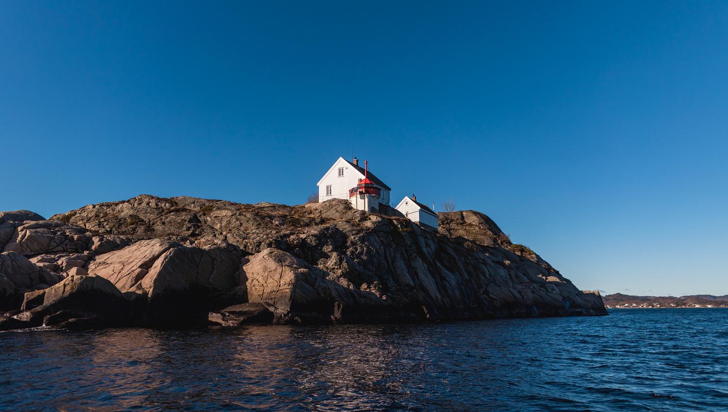 Utsikt inn fra havet og mot Hatholmen fyr