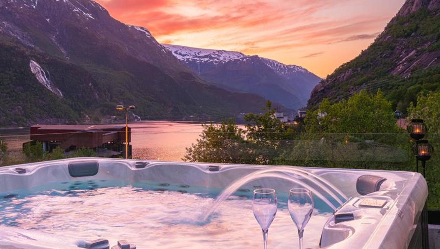 Boblebad på Tyssedal Hotel med utsikt mot fjorden i solnedgang.