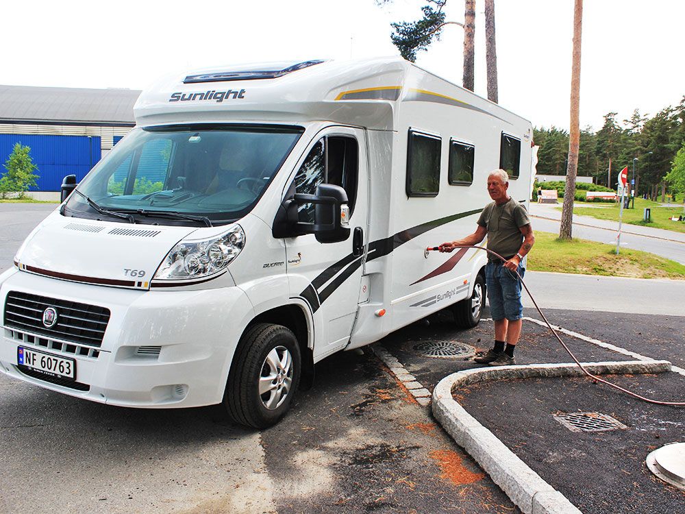 man fills water on his motorhome in motorhome parking in Skien leisure park 