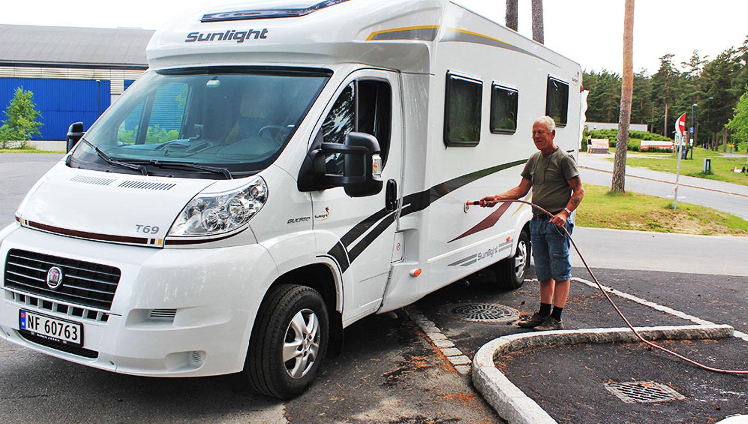 man fills water on his motorhome in motorhome parking in Skien leisure park