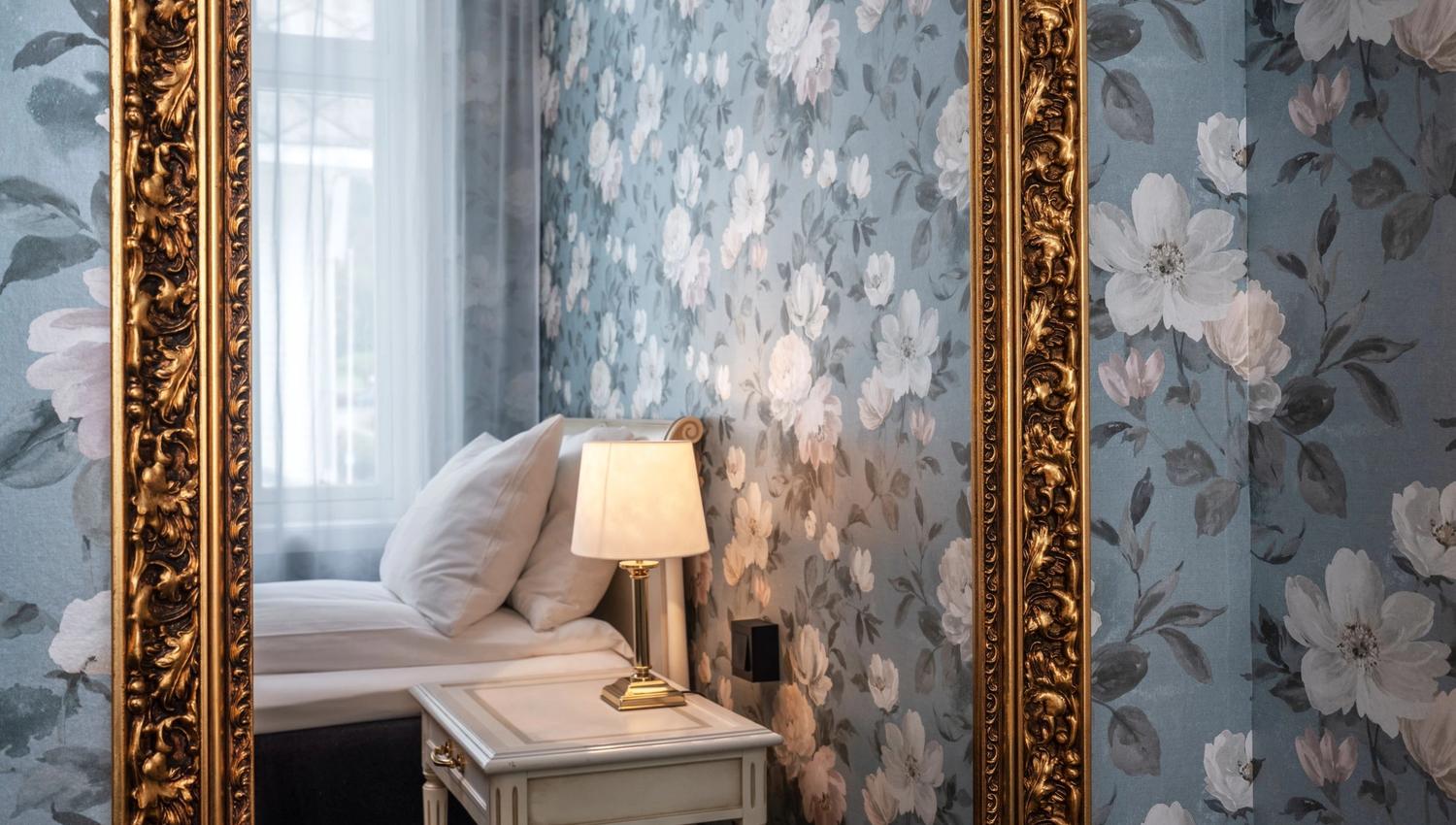 Stilige detaljar på Thon Hotel Sandven – klassisk spegel med gullramme reflekterer den elegante innreiinga.