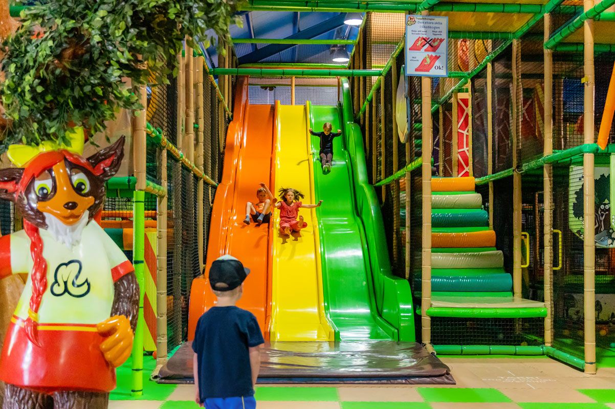 Indoor playground featuring colorful slides and mascots at Mikkelparken