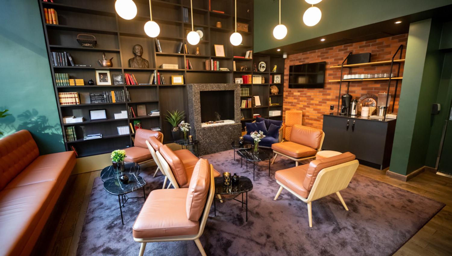 Lounge with sofa and chairs. Bookshelf. Hotell Bondeheimen, Oslo. Photo