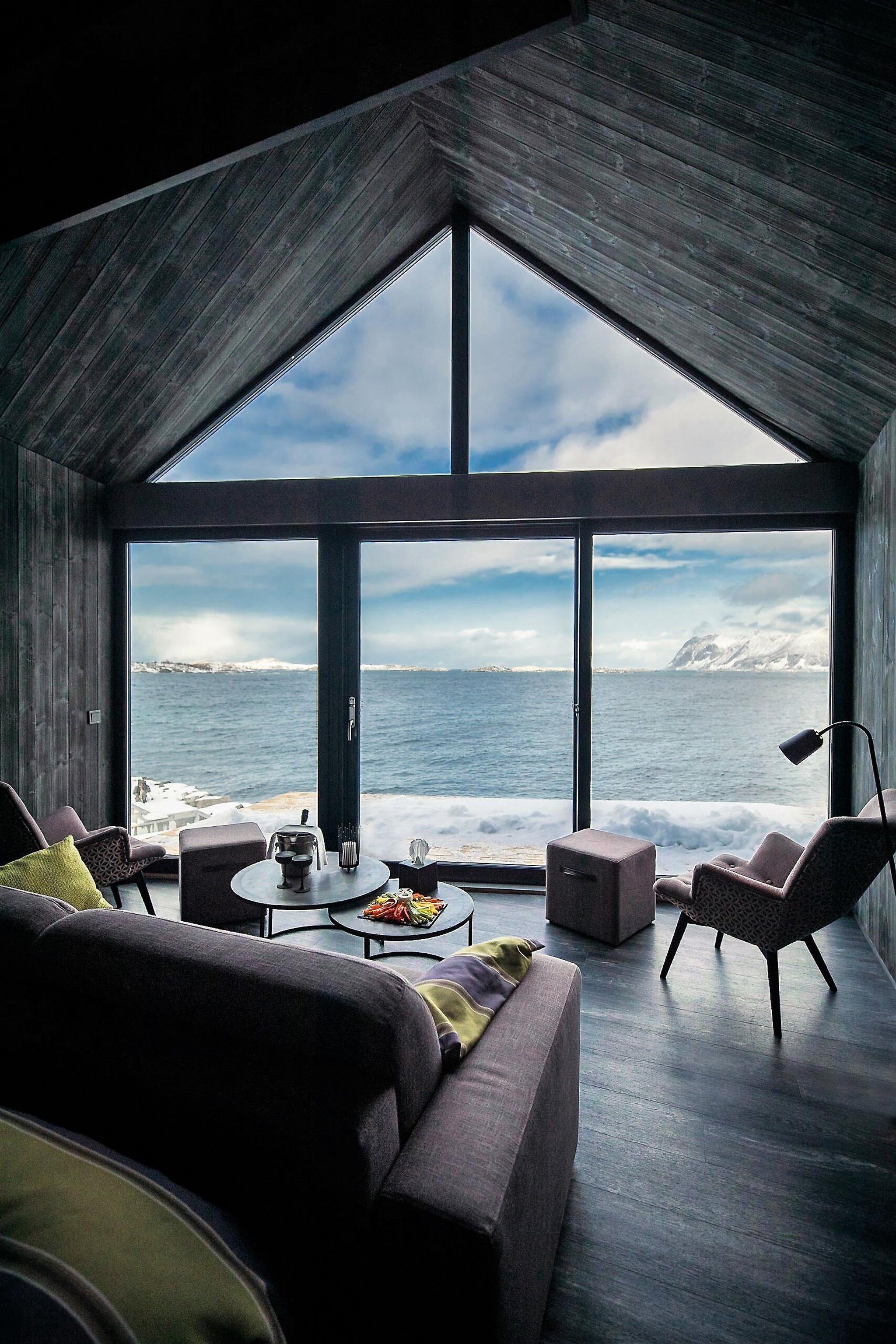 modern living room with large windows that have a fantastic view of the fjord and mountains
