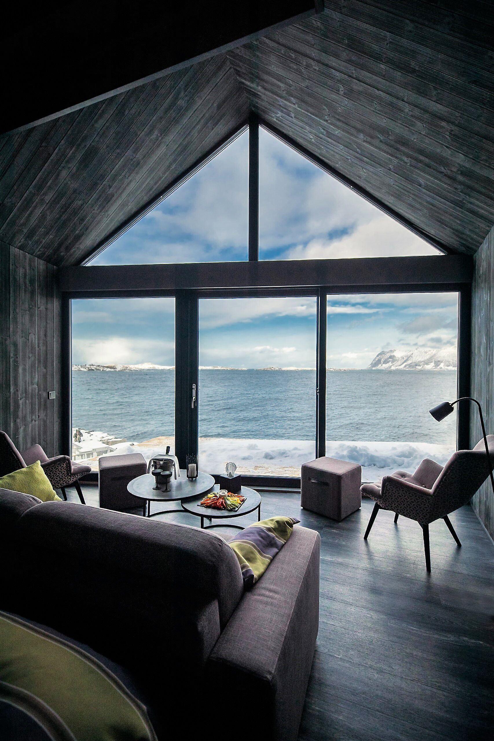 modern living room with large windows that have a fantastic view of the fjord and mountains