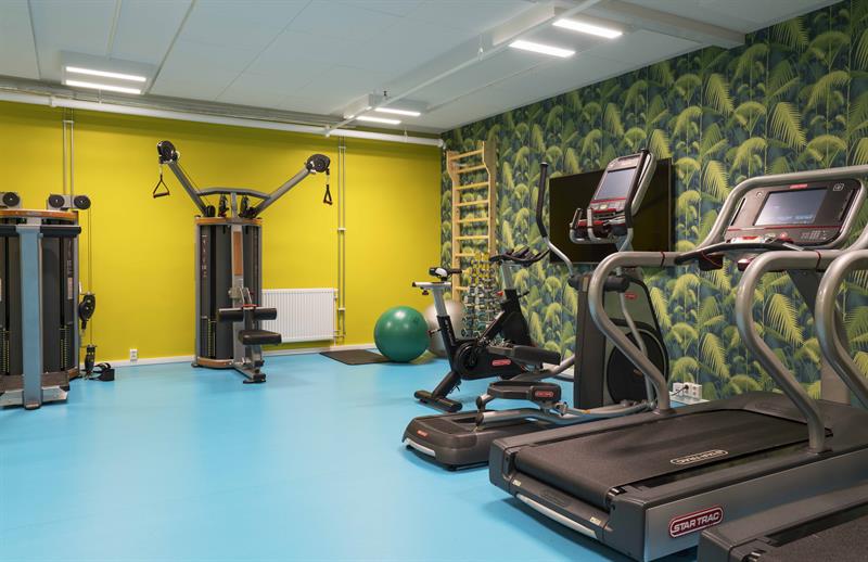 treningsrom med gul vegg og tredemøller