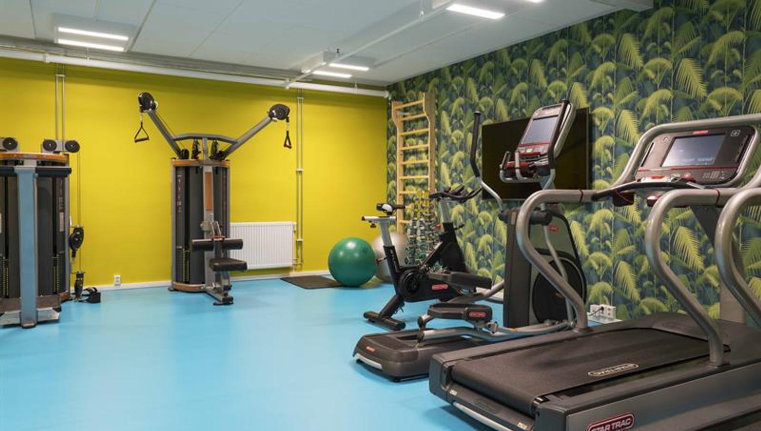 treningsrom med gul vegg og tredemøller
