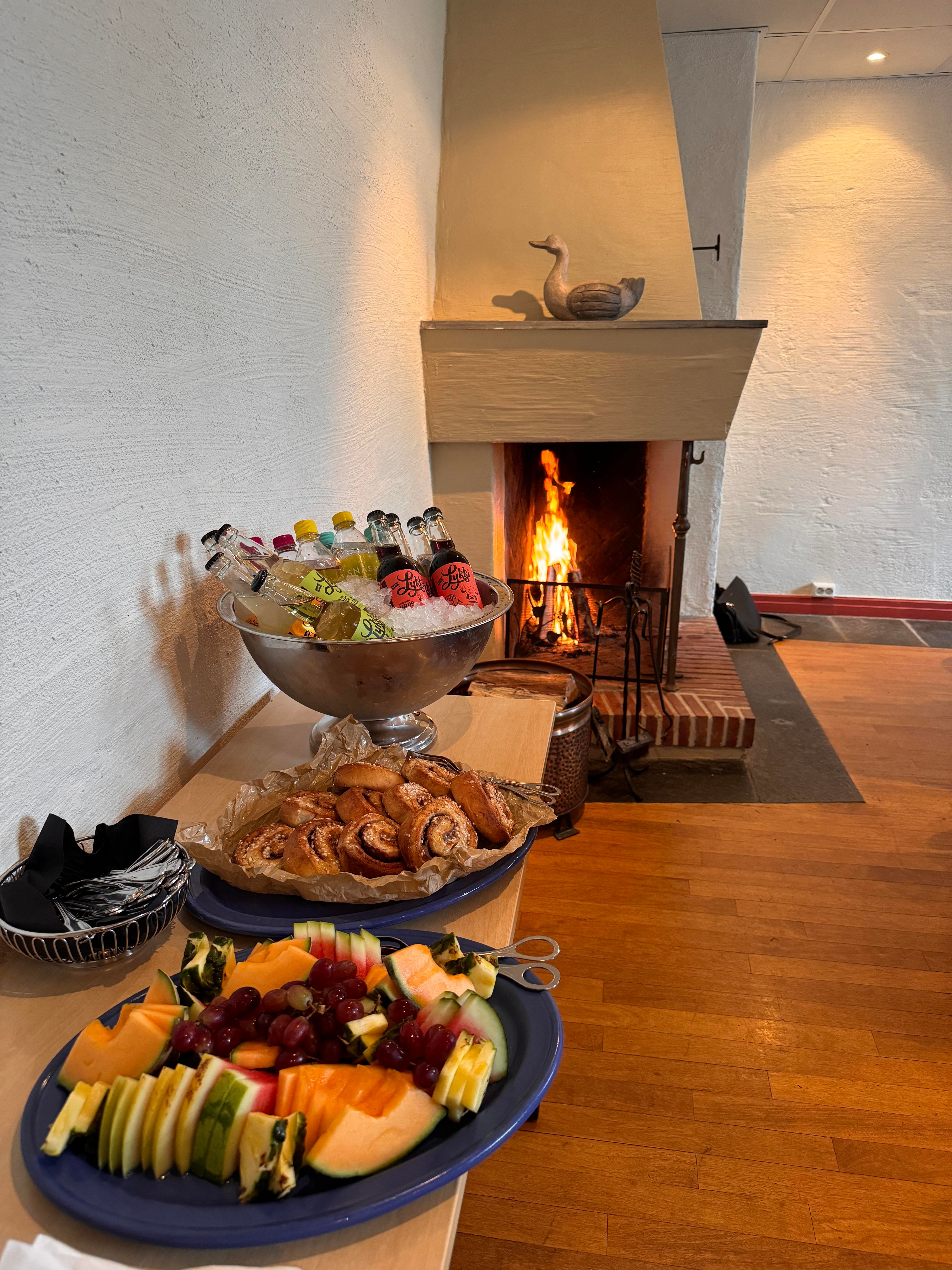Frukt på fat, fat med kanelboller, fyr i peis